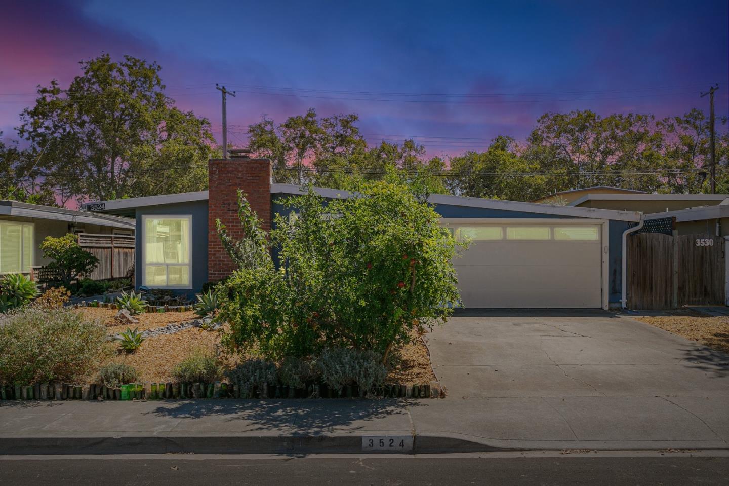 a front view of a house with a yard and potted plants