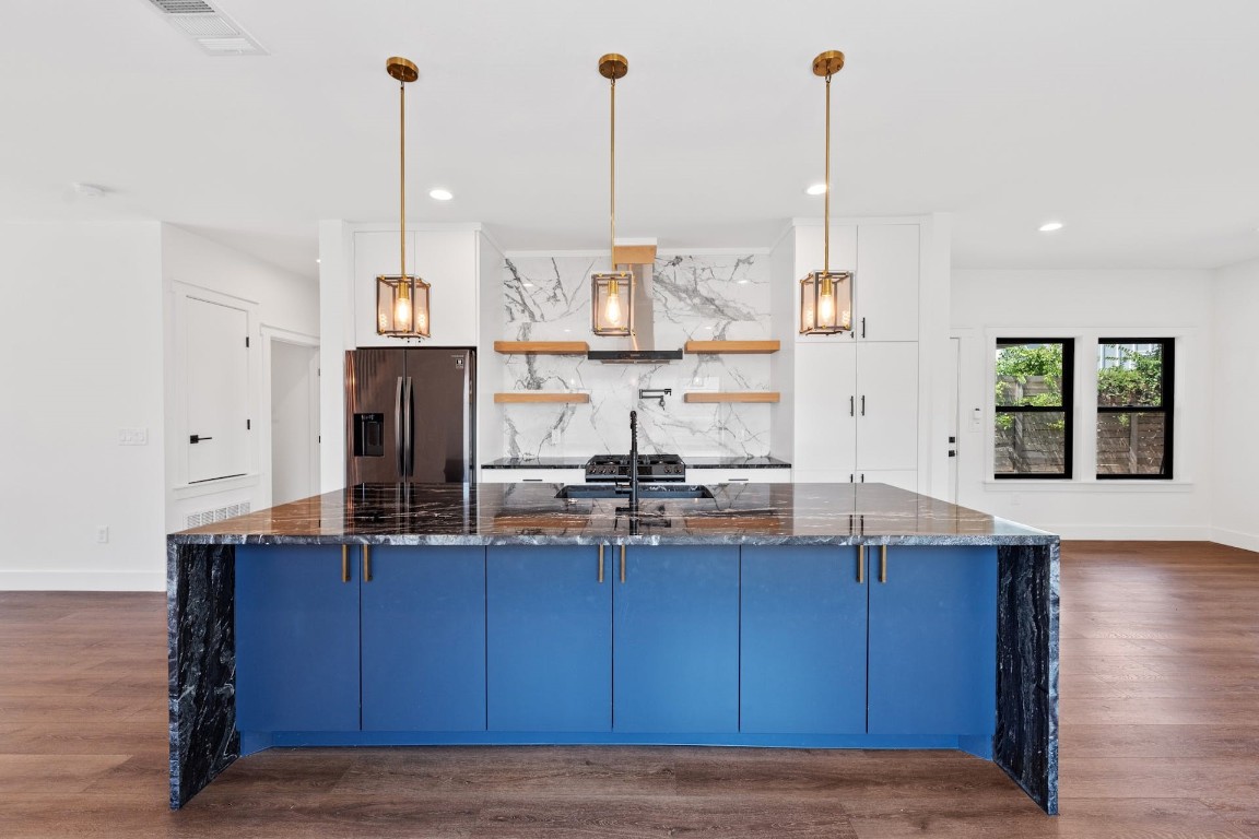 a kitchen with stainless steel appliances granite countertop wooden cabinets sink and stove