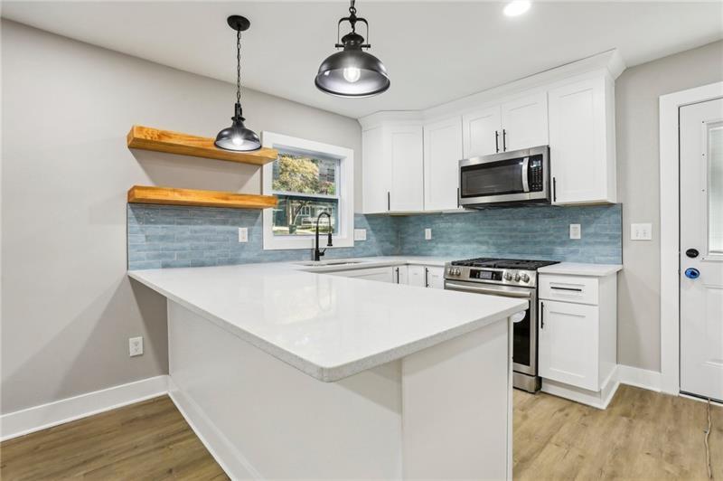 a kitchen with stainless steel appliances a stove a sink and a microwave