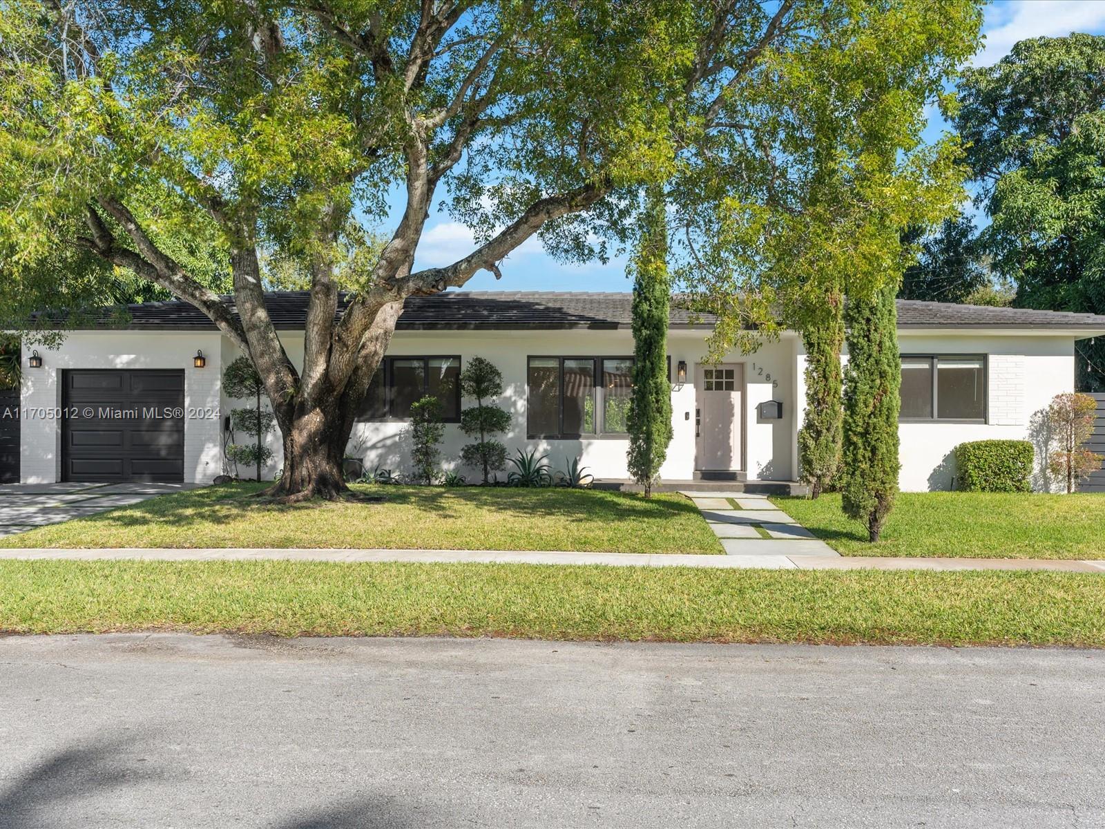 a front view of a house with a yard and a garage