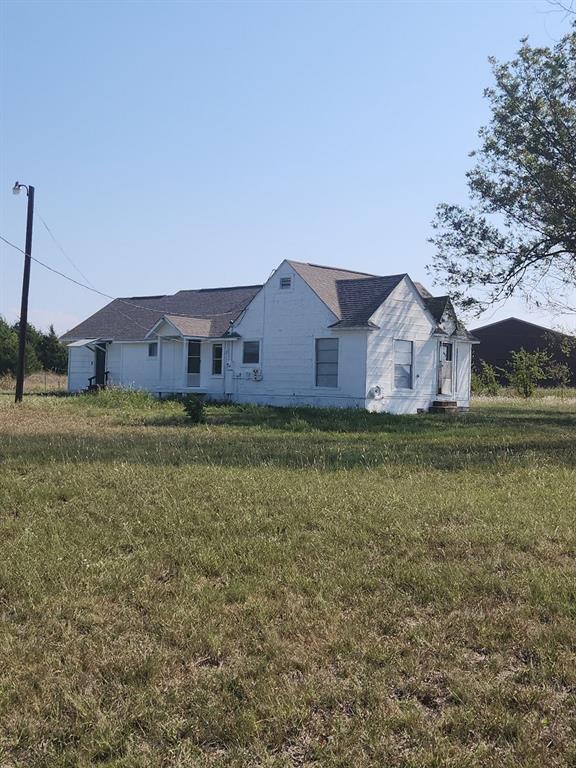 a view of a house with a big yard and large trees