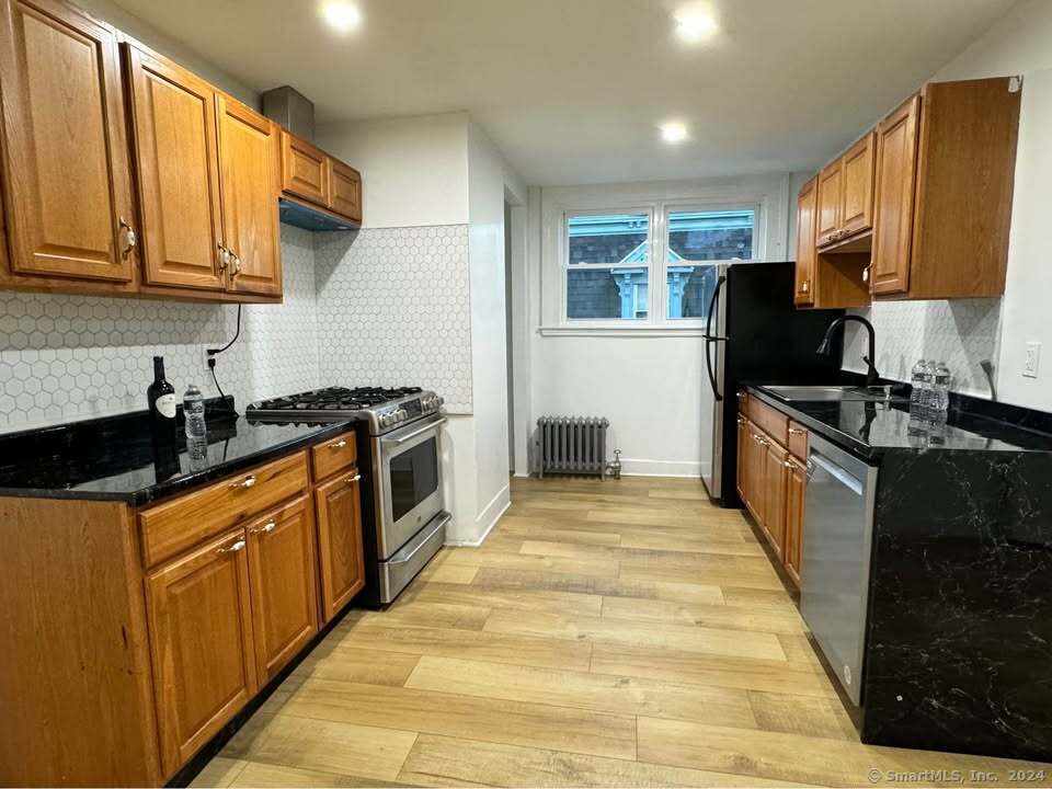 a kitchen with stainless steel appliances granite countertop a stove a sink and a microwave