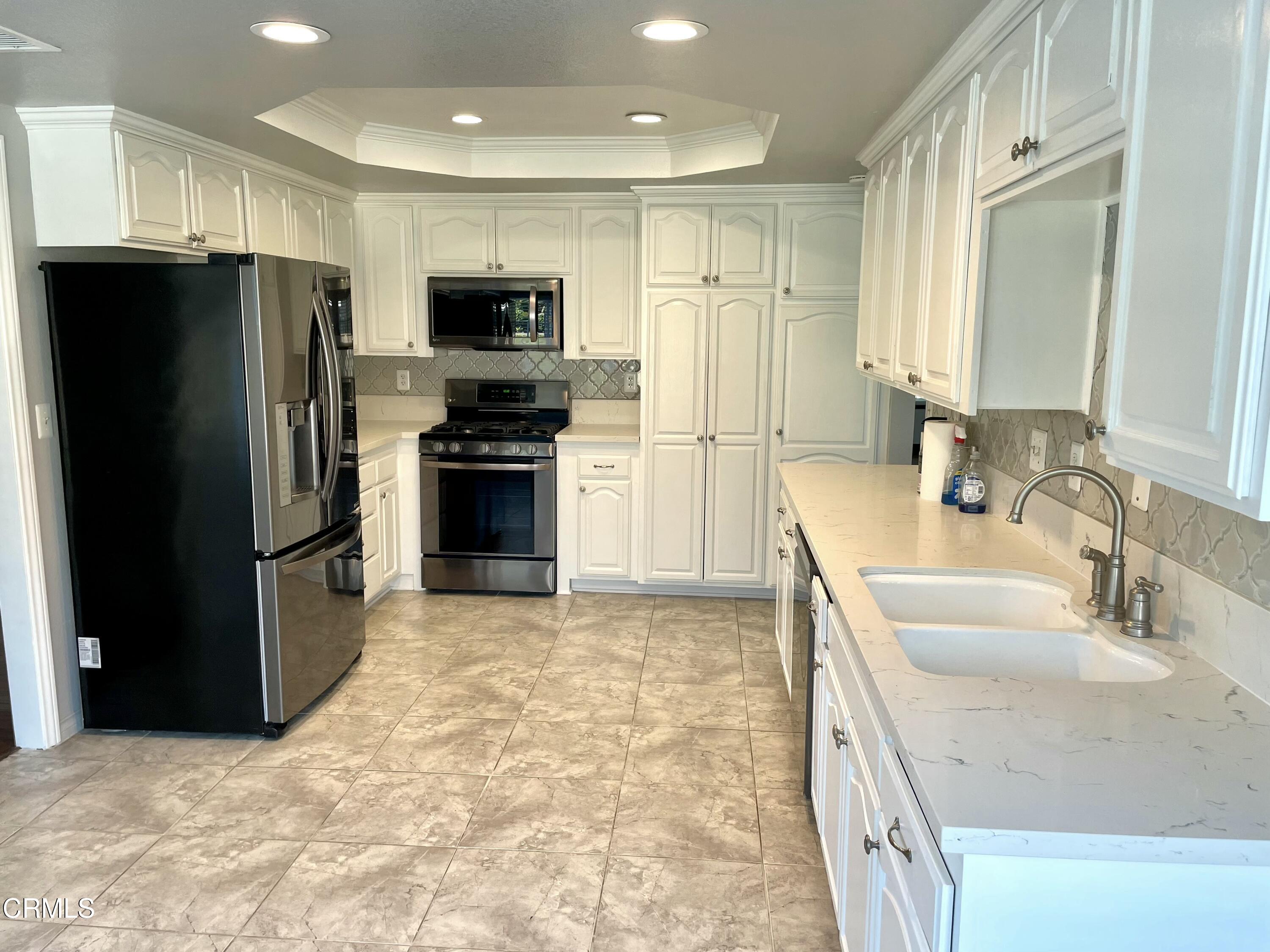 a kitchen with stainless steel appliances granite countertop a refrigerator and a sink