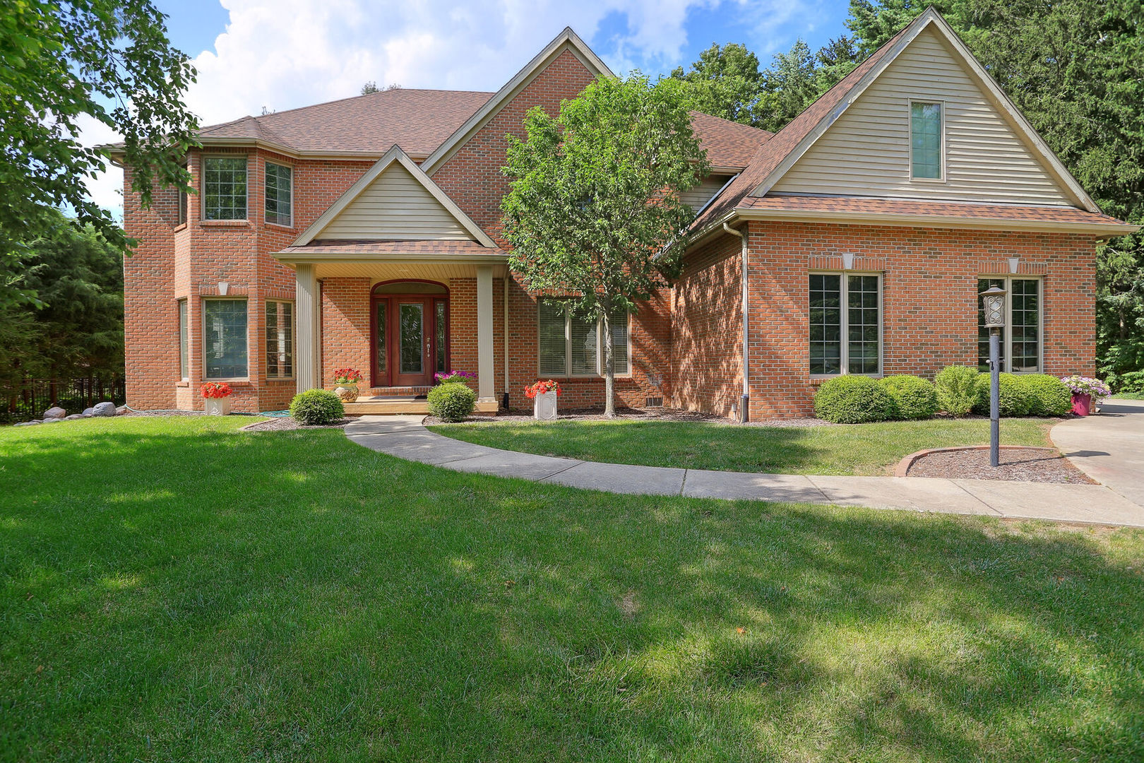 a front view of a house with a yard and potted plants