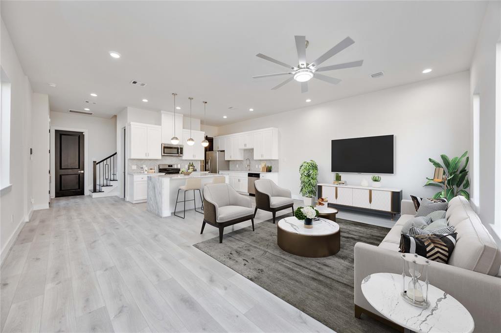 a living room with furniture kitchen view and a flat screen tv