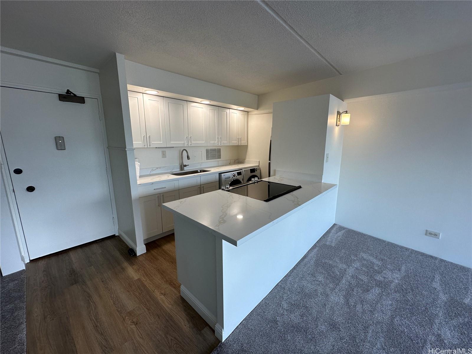 a kitchen with a sink cabinets and wooden floor