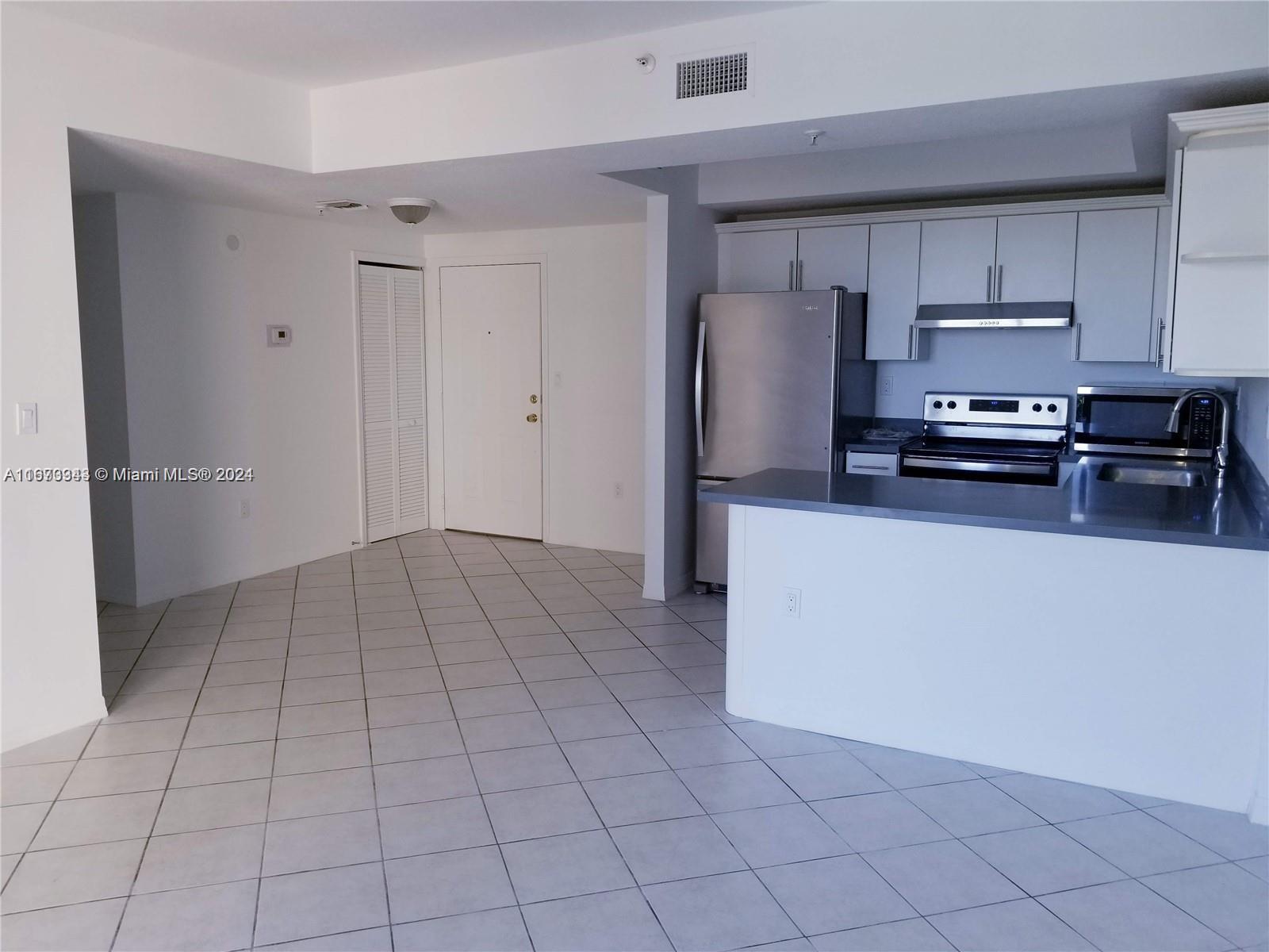 a kitchen with stainless steel appliances a refrigerator sink and microwave