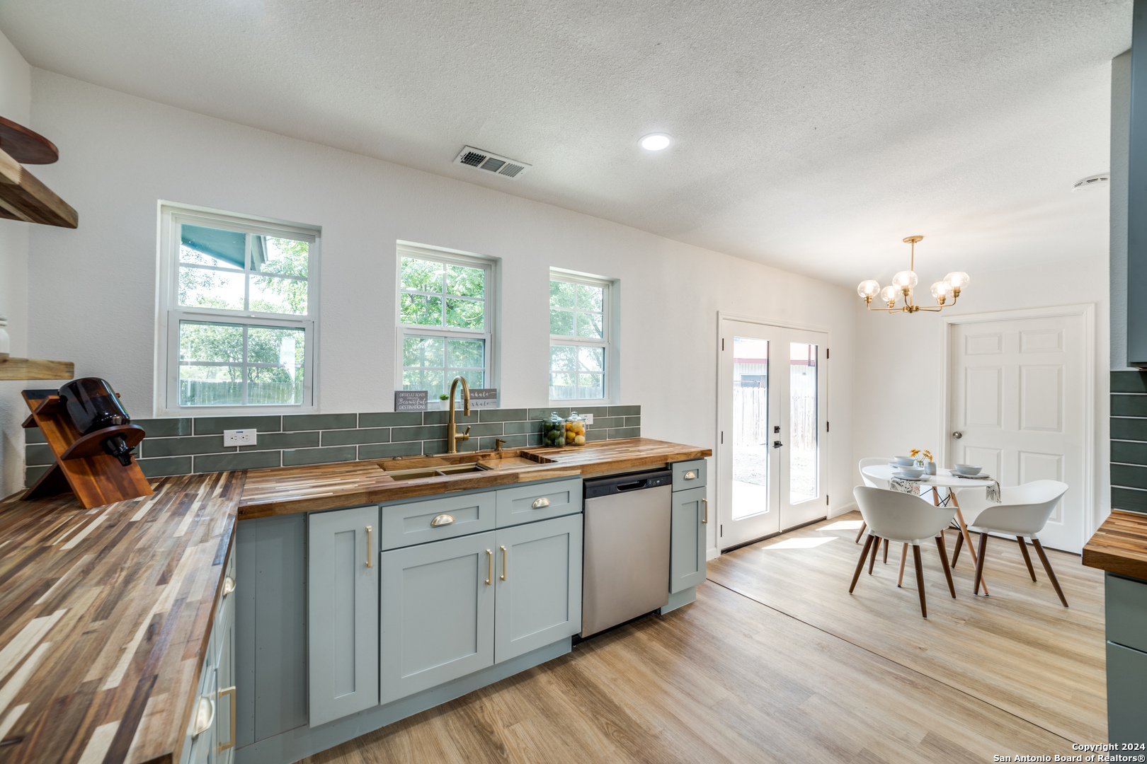 a large kitchen with lot of cabinets and wooden floor