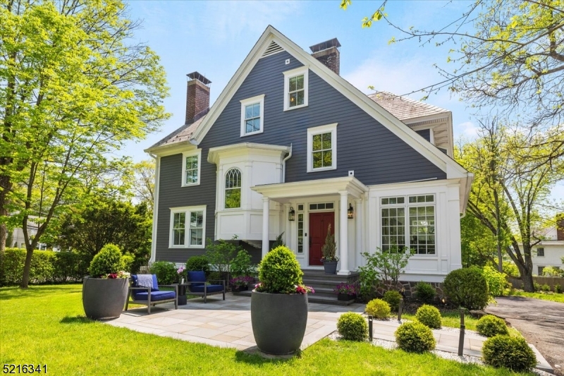 a front view of a house with sitting area and garden