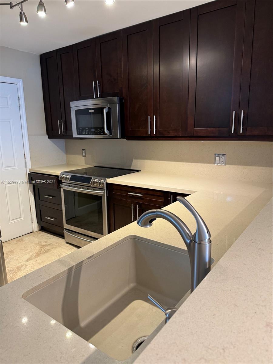 a kitchen with stainless steel appliances wooden cabinets and a sink