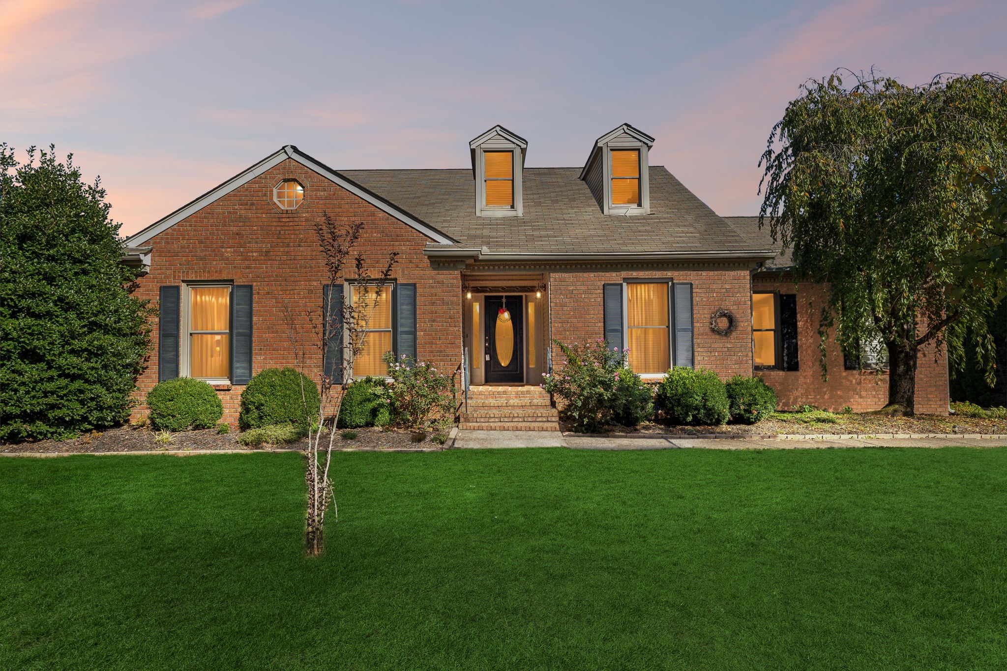 a front view of house with yard and green space