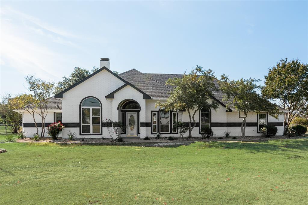 a front view of house with yard and trees