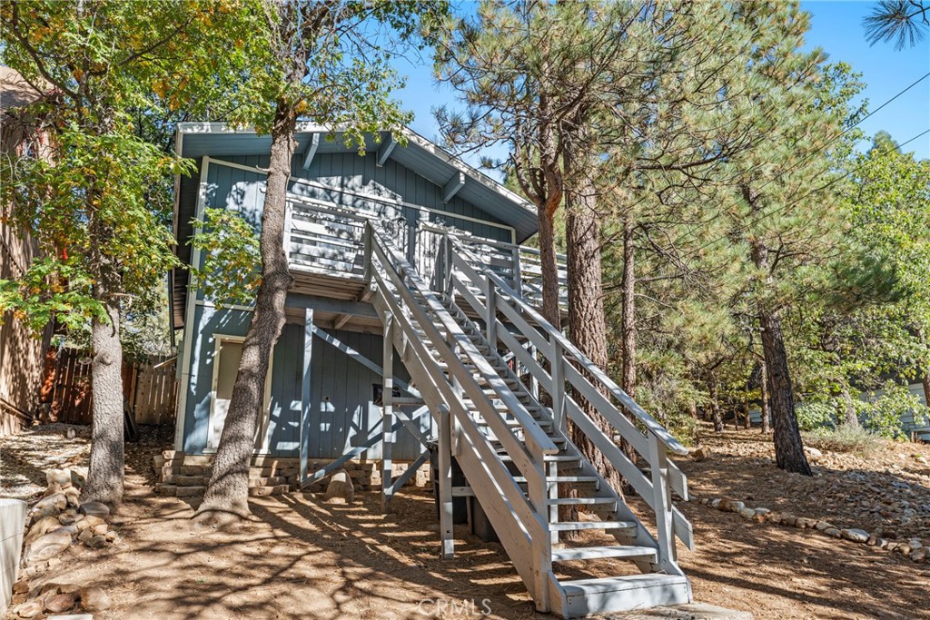 a view of a wooden building with large tree