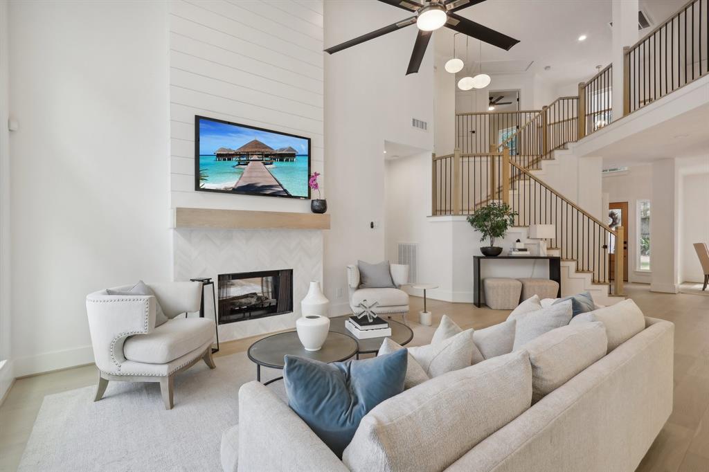 a living room with furniture a fireplace and a ceiling fan