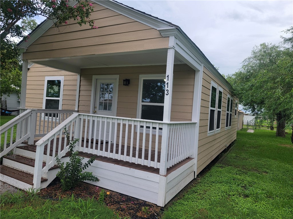 a view of a house with a yard and deck