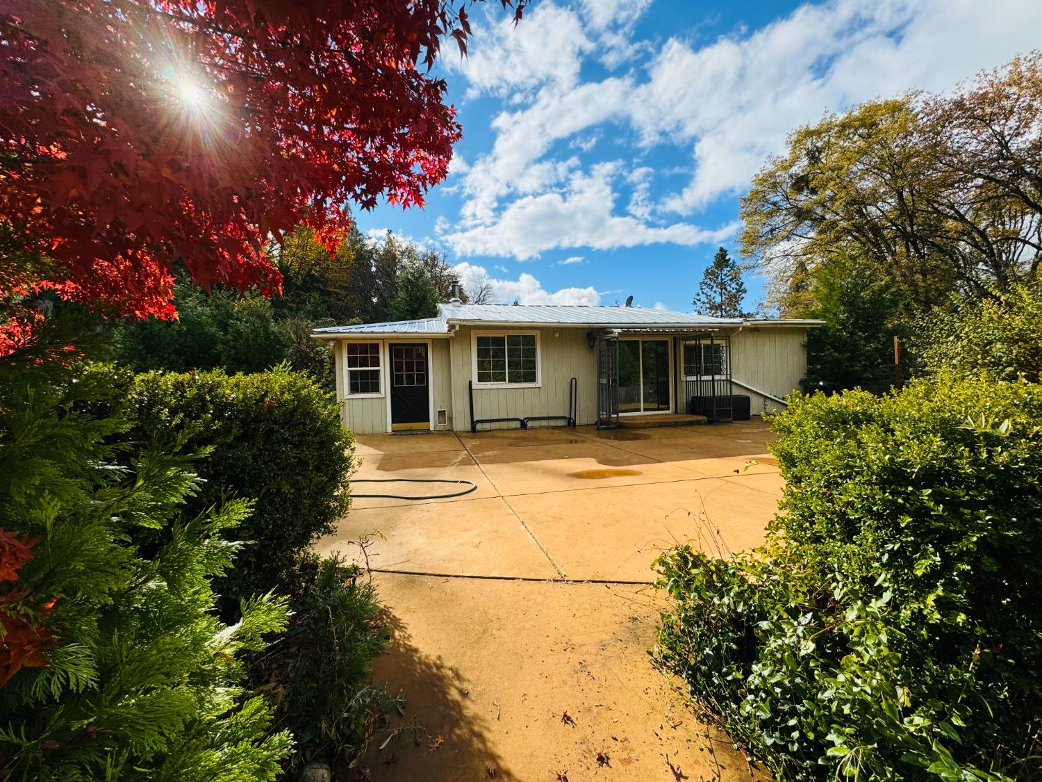 a front view of house with yard and trees around