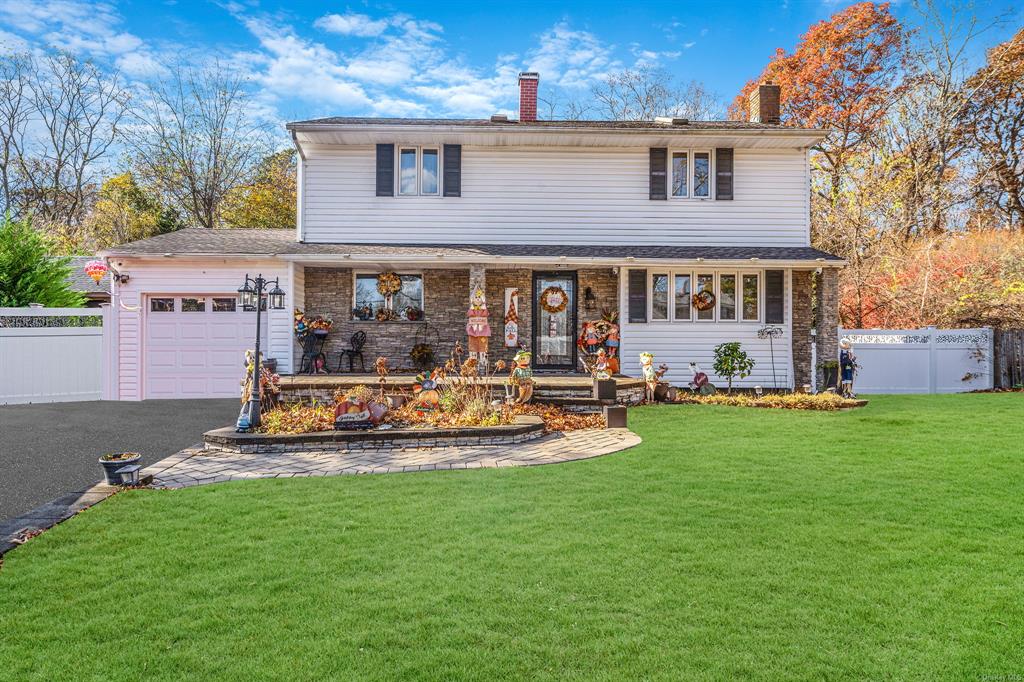 Front of property with a front yard, a porch, and a garage