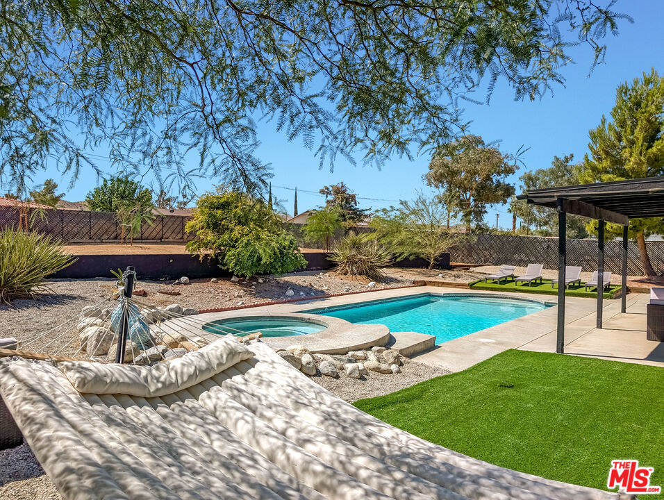 a swimming pool with outdoor seating and garden