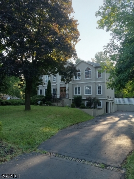 a view of a big yard in front of a house with large tree