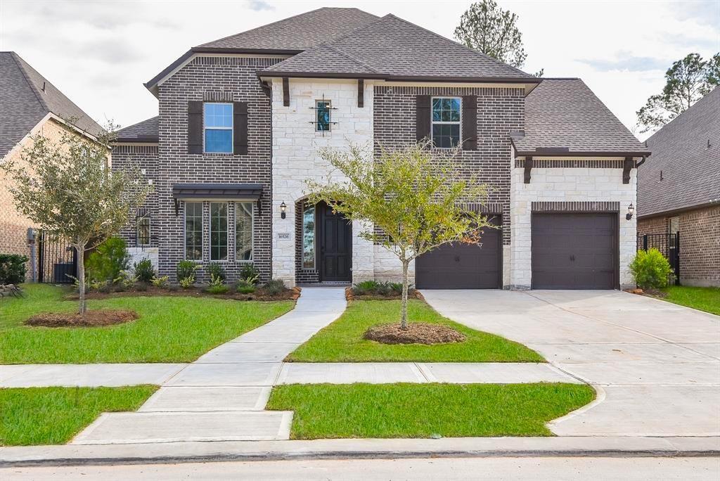 a front view of a house with a yard and garage