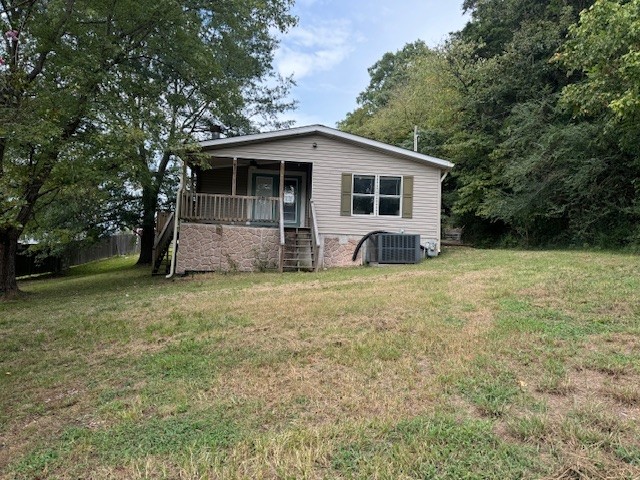 a front view of house with yard and trees in the background