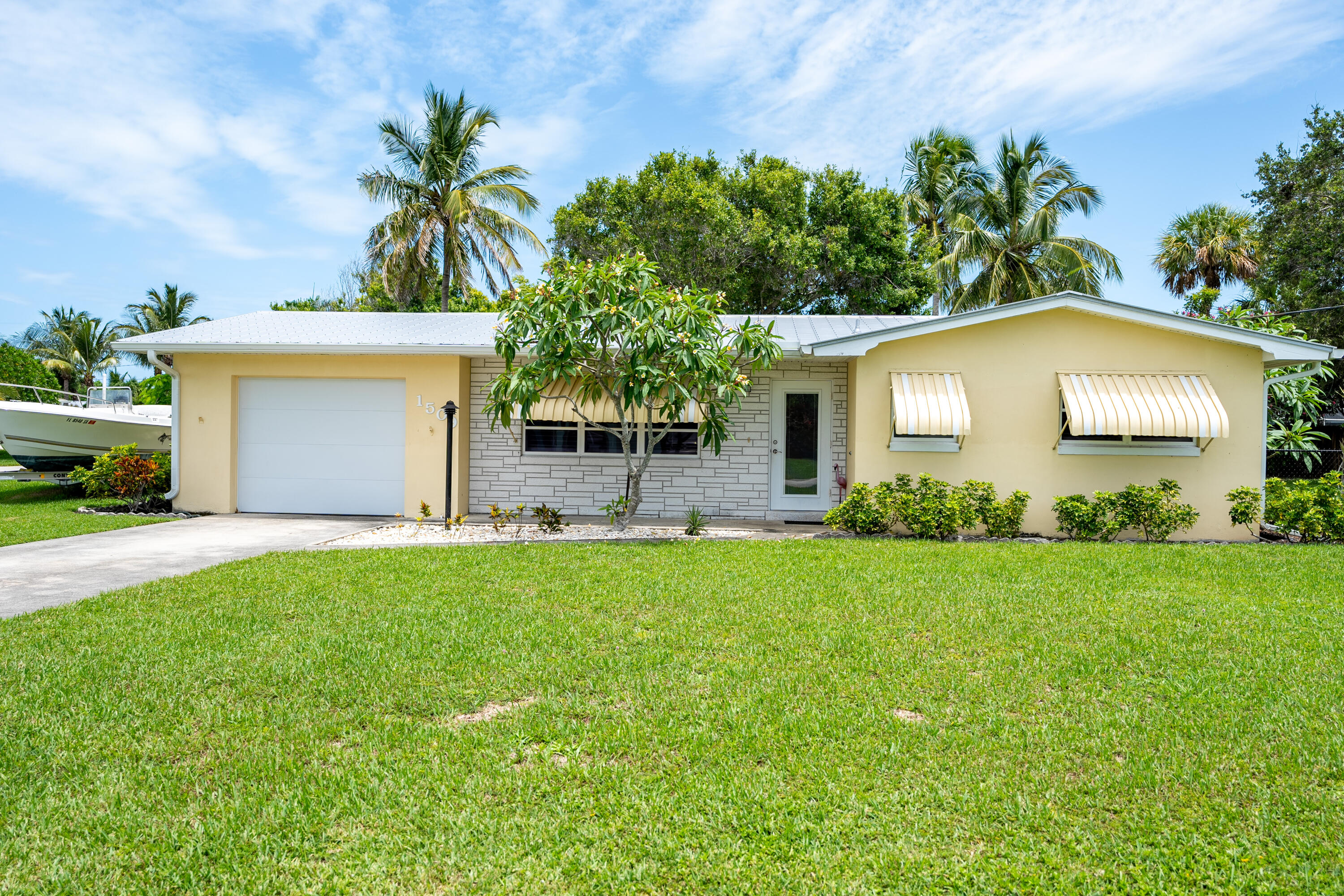 a front view of house with yard and trees in the background