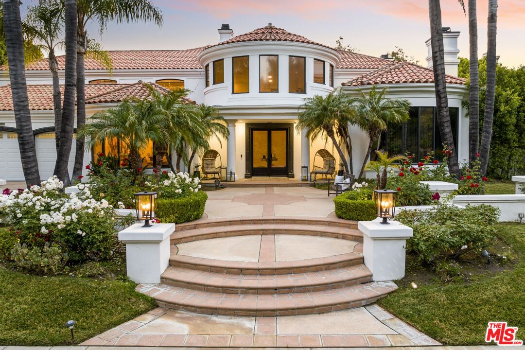 a front view of a house with fountain and garden