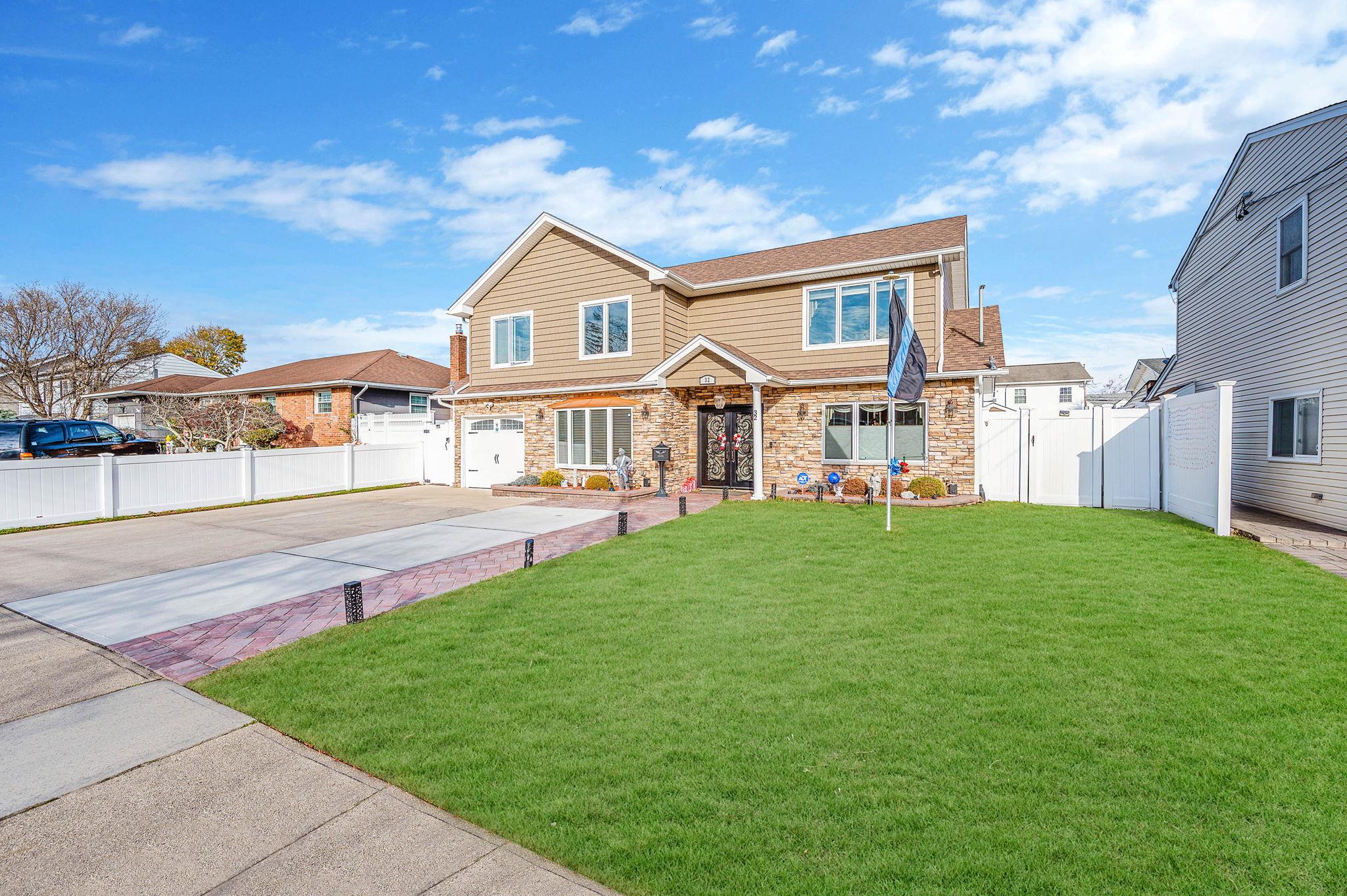 View of front of house with a garage and a front lawn