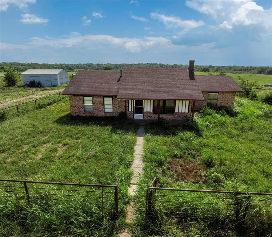 an aerial view of a house with a garden and lake view