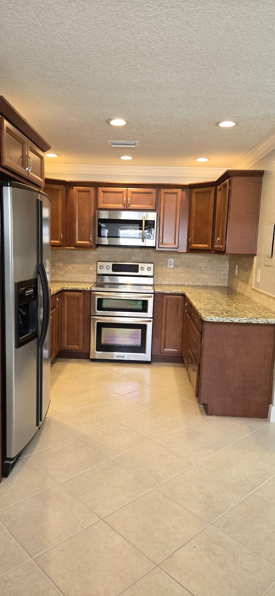 a kitchen with stainless steel appliances a stove a sink and a refrigerator