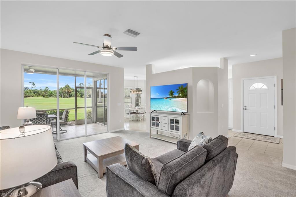 a living room with furniture large windows and a flat screen tv