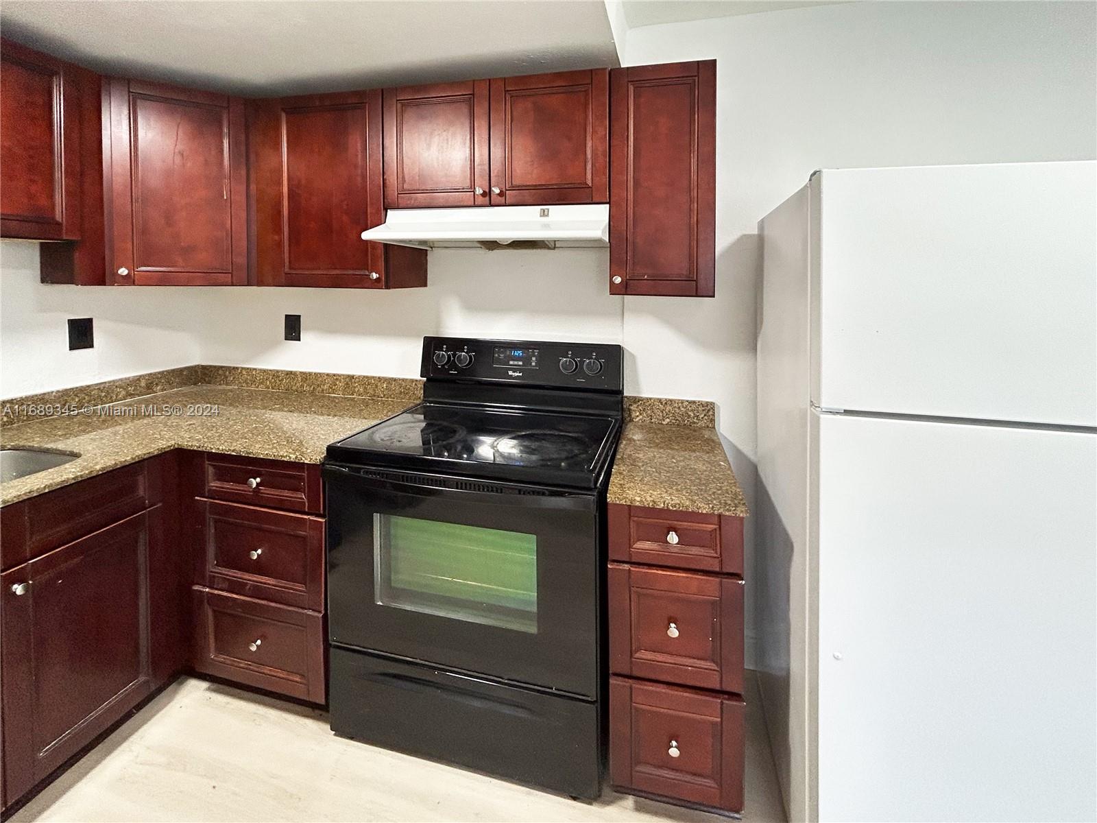 a kitchen with wooden cabinets and a stove top oven