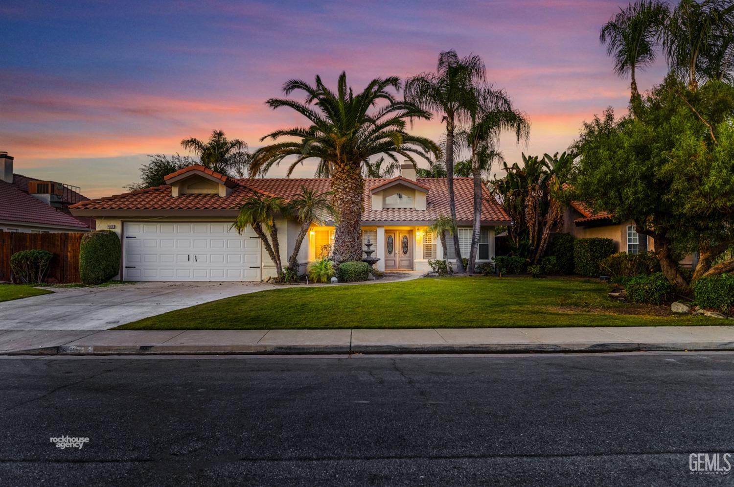 a front view of a house with a garden and a yard