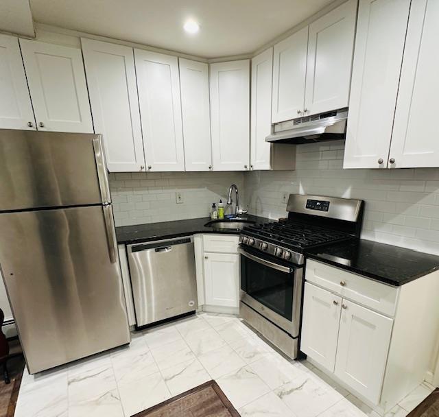 a kitchen with granite countertop white cabinets and stainless steel appliances