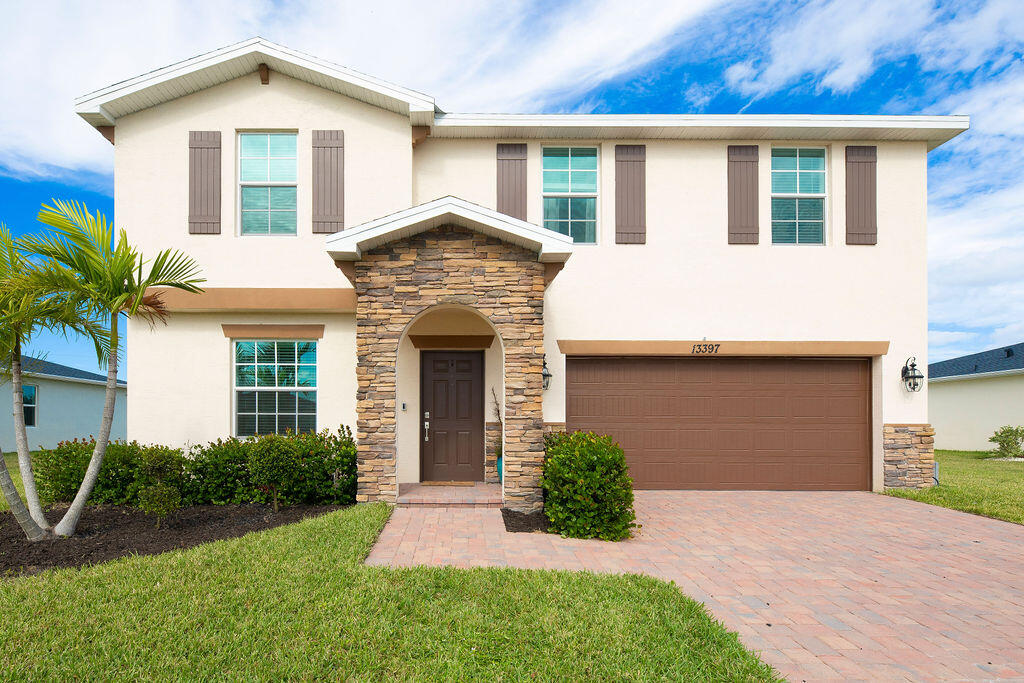 a front view of a house with a yard and garage