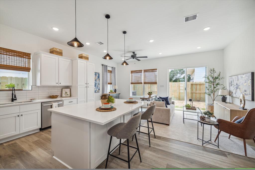 a kitchen with a table chairs stove and white cabinets