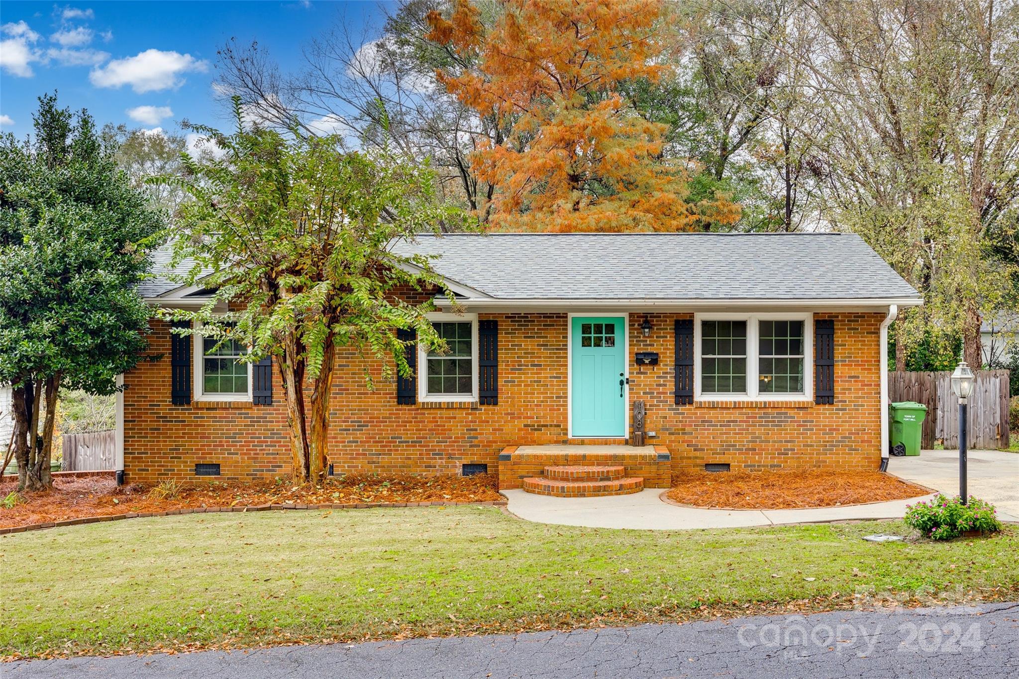 a front view of a house with yard and green space