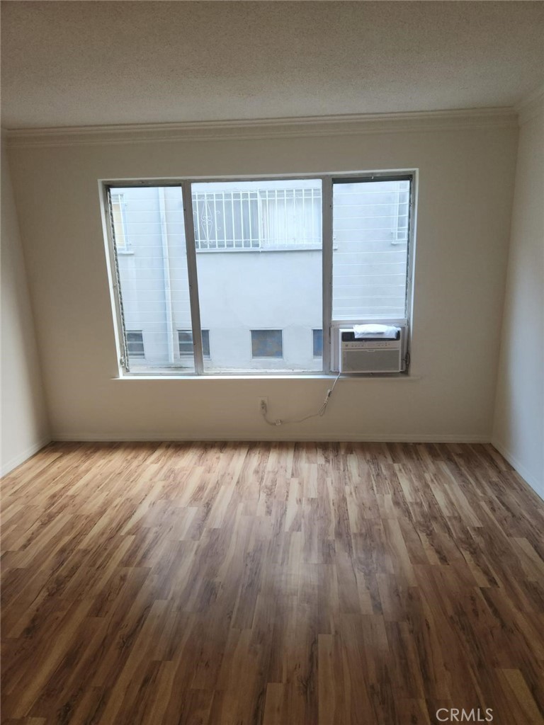 a view of a room with wooden floor and cabinet