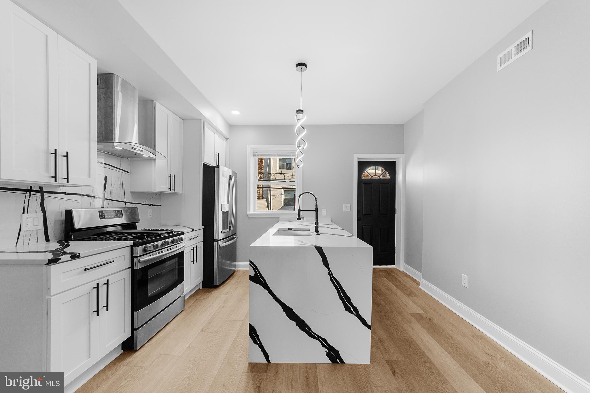 a kitchen with stainless steel appliances a stove a sink and a refrigerator