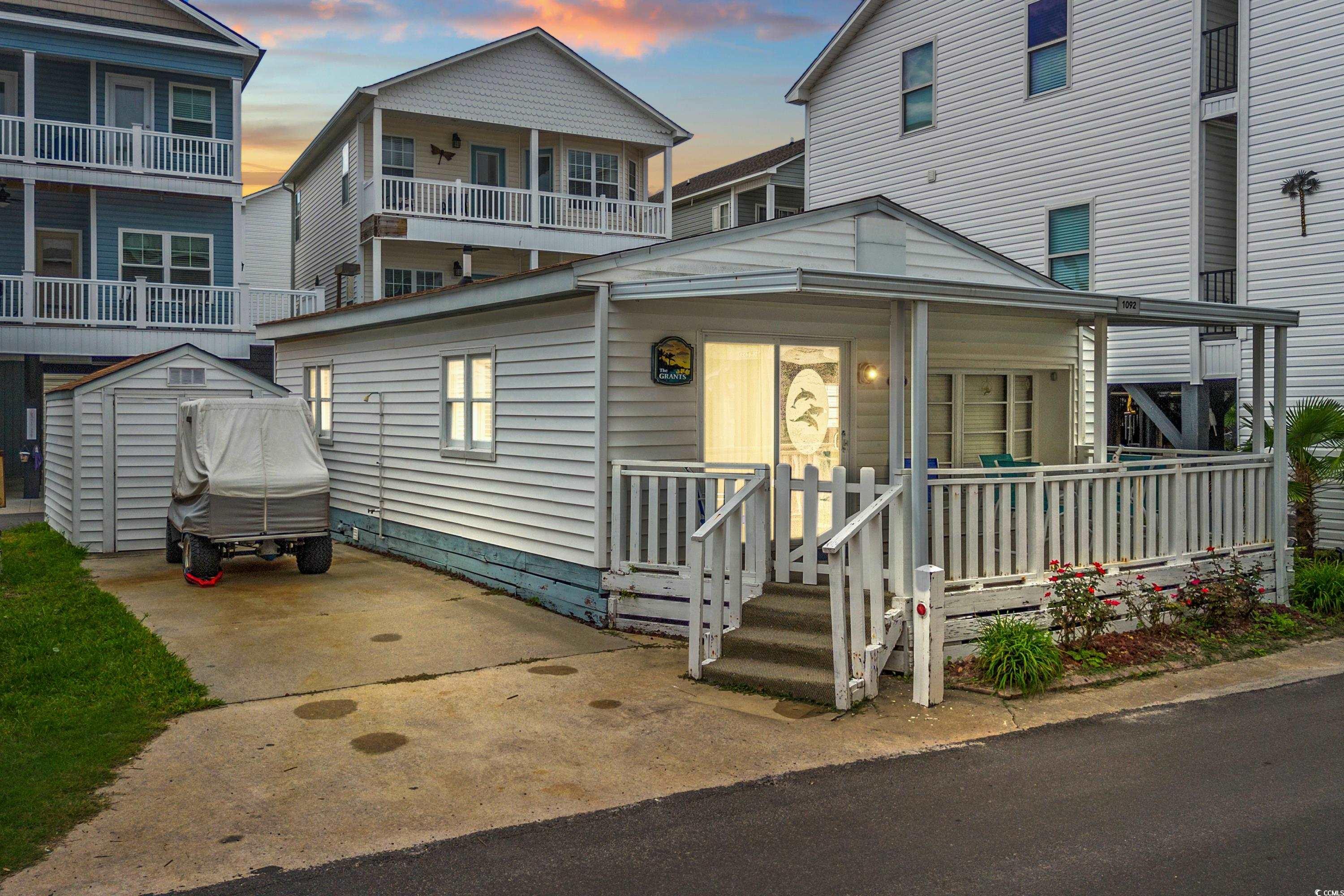 View of front of home with a storage shed and cove