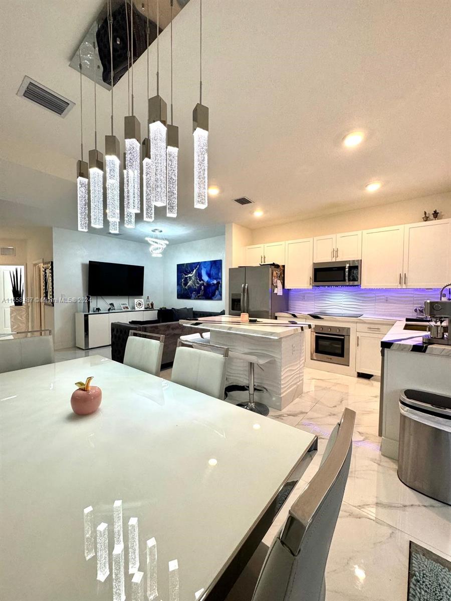 a kitchen with stainless steel appliances a stove a sink and white cabinets