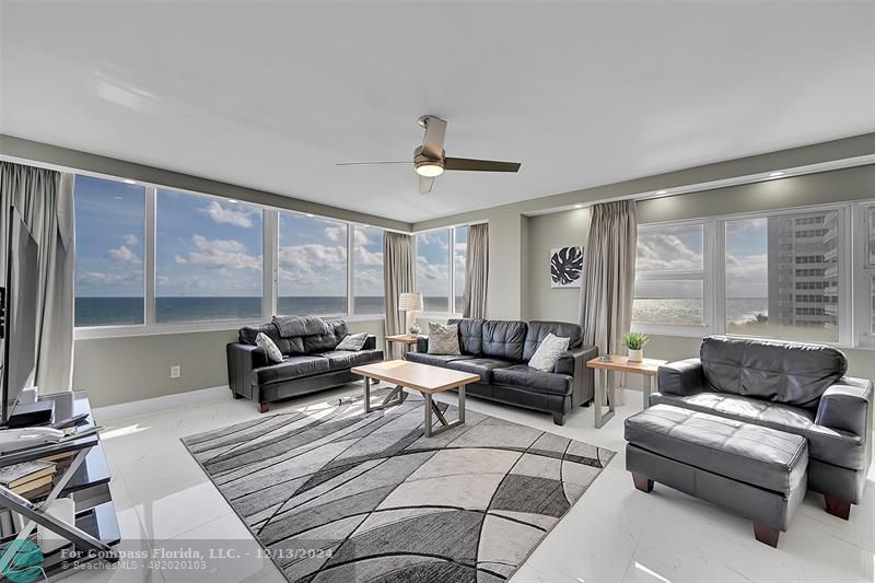 a living room with furniture and large windows