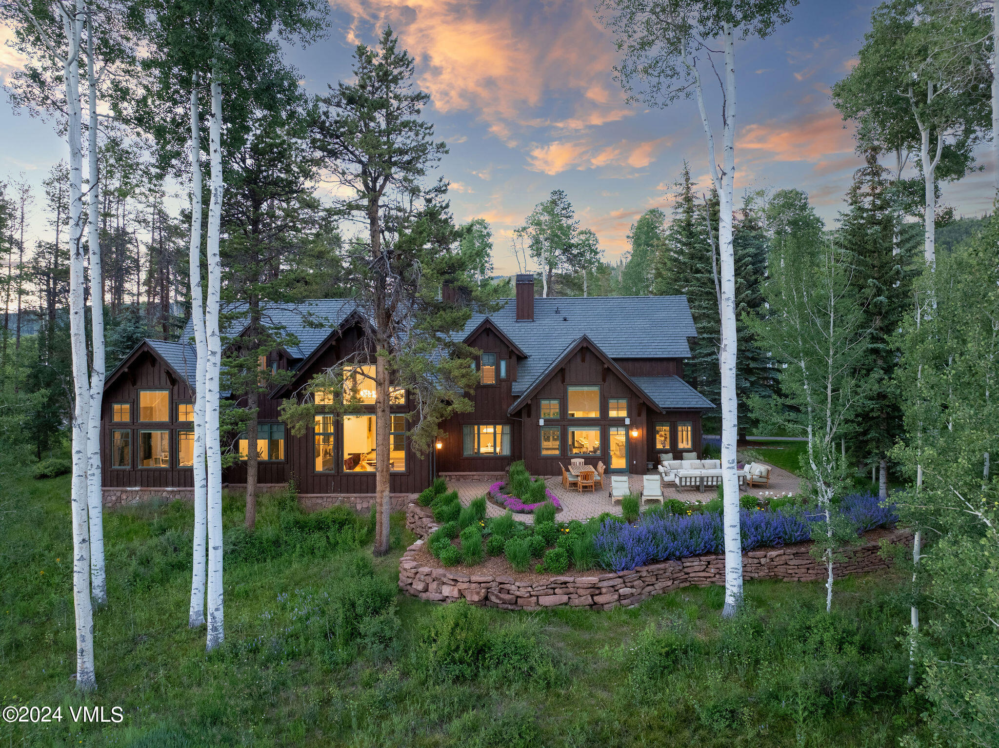 aerial view of a house with a big yard and large trees