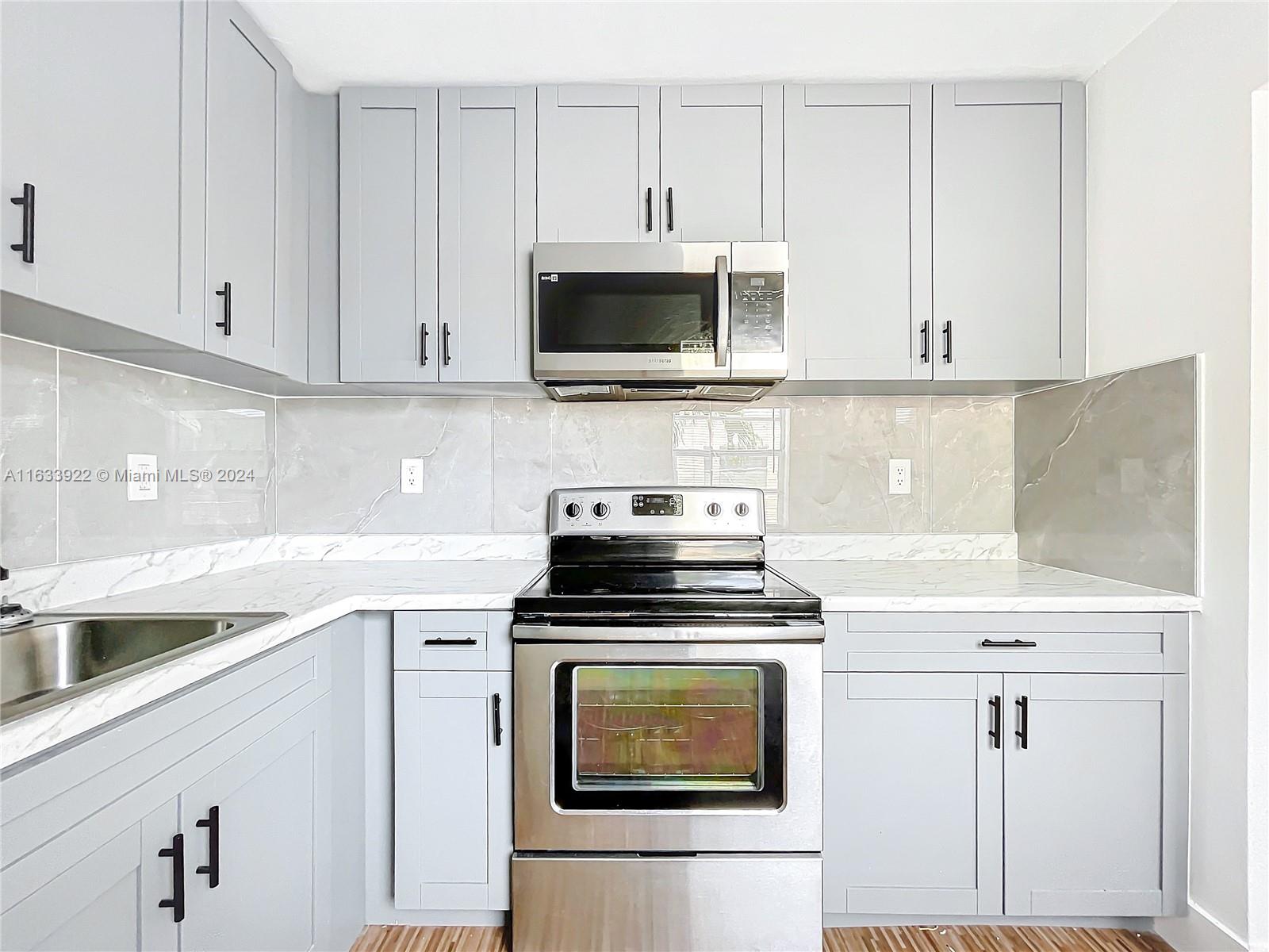 a kitchen with white cabinets and stainless steel appliances