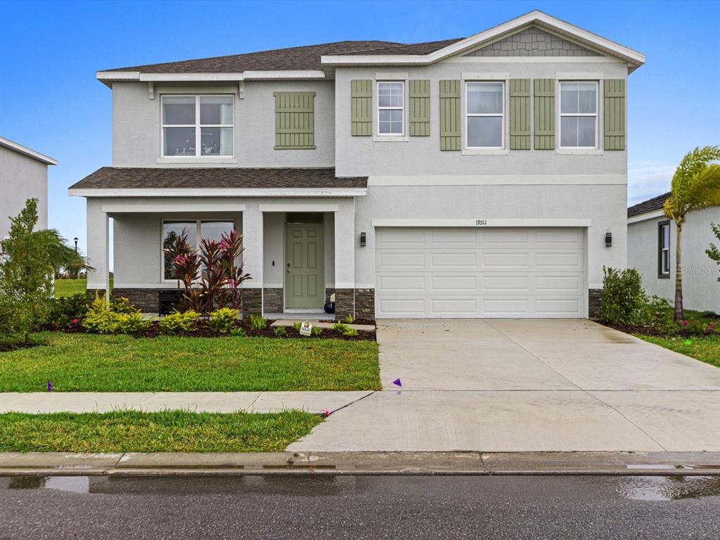 a front view of a house with a yard and garage