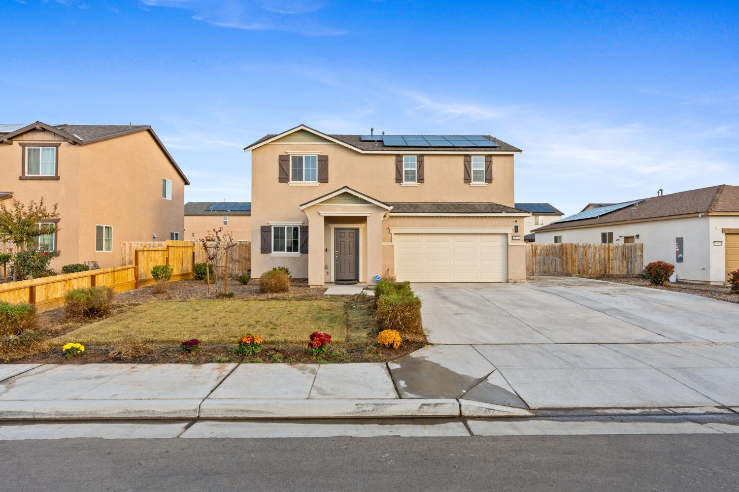 a front view of a house with garage and parking