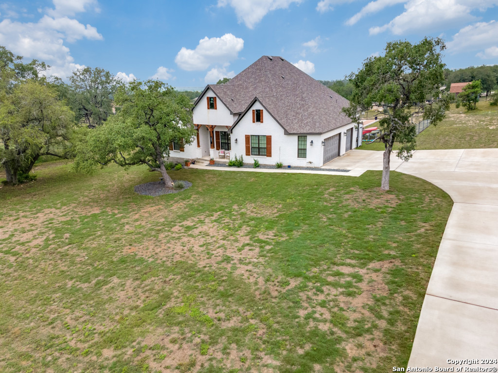 a aerial view of a house with a yard table and chairs