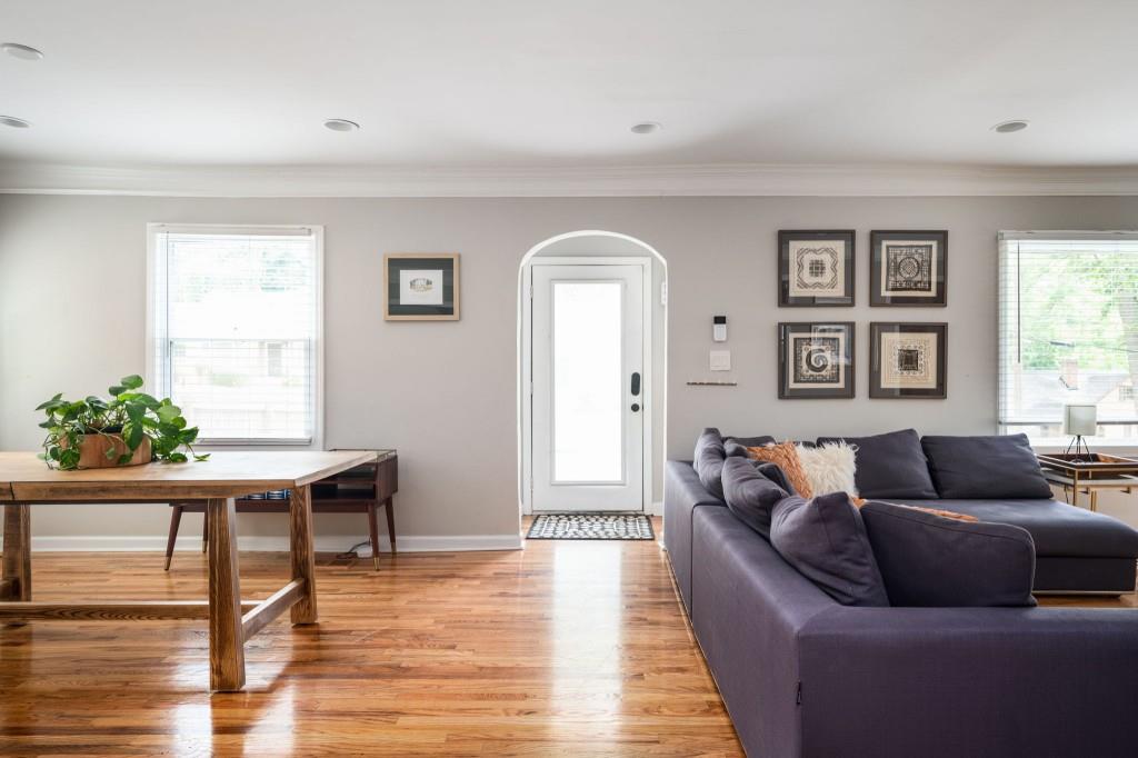 a living room with furniture and a wooden floor