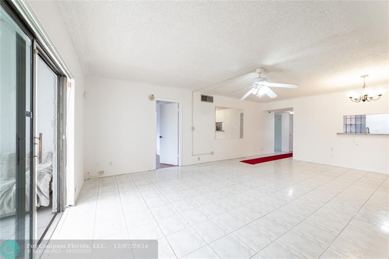 an empty room with fan and windows