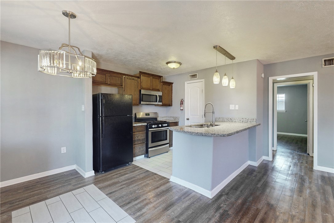 a kitchen with stainless steel appliances granite countertop a refrigerator and a sink